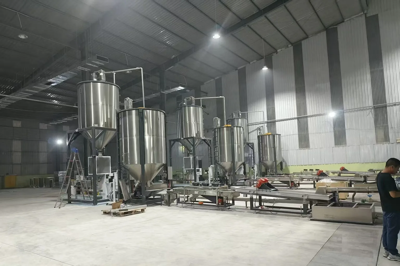 Recycled plastic pellet storage silos at the end of the rigid pelletizing line at customer plant
